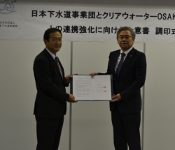 日本下水道事業団調印式（左が畑田本部長、右が福井社長）